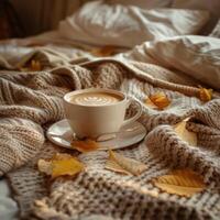 ai gerado outono folhas, copo do café e tricotado cachecol em cama foto