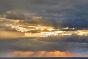 dramático nuvens de tempestade sobre Mediterrâneo mar com Sol raios quebra através foto