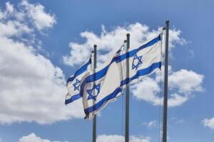 quatro israelense bandeiras orgulhosamente acenando debaixo a azul céu com colinas dentro a fundo foto