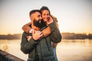 feliz casal apreciar gastos Tempo juntos ao ar livre em uma pôr do sol. foto