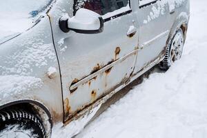 oxidado pontos em a frente porta do a carro. corrosão do metal. a efeitos do sal e umidade em a carro. reparar do a corpo do transporte foto
