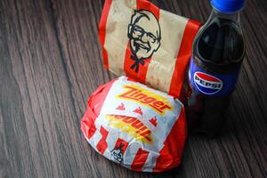 Bangkok, Tailândia - marcha 3, 2024 - kfc frango zinger hamburguer e fresco fritas com Pepsi refrigerante colocada em uma Preto de madeira mesa, Leve embora comida, lixo comida, kfc frito frango, Pepsi Novo logotipo. foto