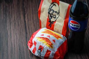 Bangkok, Tailândia - marcha 3, 2024 - kfc frango zinger hamburguer e fresco fritas com Pepsi refrigerante colocada em uma Preto de madeira mesa, Leve embora comida, lixo comida, kfc frito frango, Pepsi Novo logotipo. foto