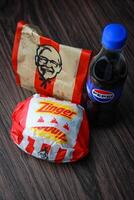 Bangkok, Tailândia - marcha 3, 2024 - kfc frango zinger hamburguer e fresco fritas com Pepsi refrigerante colocada em uma Preto de madeira mesa, Leve embora comida, lixo comida, kfc frito frango, Pepsi Novo logotipo. foto