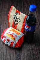 Bangkok, Tailândia - marcha 3, 2024 - kfc frango zinger hamburguer e fresco fritas com Pepsi refrigerante colocada em uma Preto de madeira mesa, Leve embora comida, lixo comida, kfc frito frango, Pepsi Novo logotipo. foto