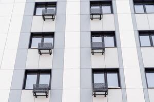 janelas do a apartamento prédio. ar condicionamento debaixo cada janela. moderno residencial construção com todos Facilidades. alojamento dentro a cidade com conforto foto