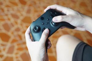 fechar acima mãos aguarde Preto joysticks ou jogos controlador console. conceito, tecnologia dispositivo para entretenimento sobre conectados controlo remoto vídeo jogos para computador tela. hobby, tempo livre e lazer atividade. foto