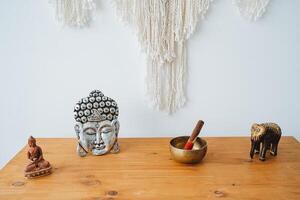 objetos para meditação dentro a interior estão em a mesa. elefante Buda tibetano tigela. símbolos do ioga do tranquilidade e tranqüilidade. foto
