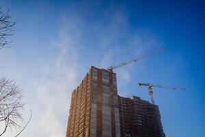 abaixo Visão do a construção do a apartamentos. a construção local do a casa contra a azul céu. foto