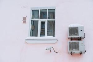 uma Novo plástico janela dentro a meio do uma Rosa muro. ar condicionamento é instalado Próximo para a janela. fofa cor do a fachada do a casa foto