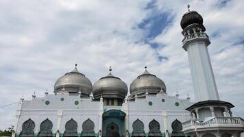 lhokseumawe, Indonésia - fevereiro 2024 a atmosfera do a al munawwarah grande mesquita durante a dia com a cidade do lhokseumawe foto