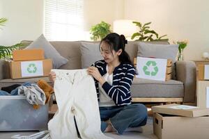 mulher pacote caixa com usava roupas para reuso. reutilizando, reciclando material e reduzindo desperdício dentro moda, segundo mão vestuário ideia. circular moda, zero desperdício conceito foto