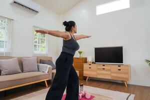 gordo mulher guardando dieta, exercício, fazendo ginástica às casa dentro vivo sala, saudável estilo de vida, alongamento, esporte, ginástica conceito foto