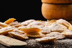 saboroso ravioli cru com farinha e manjericão na mesa de madeira foto