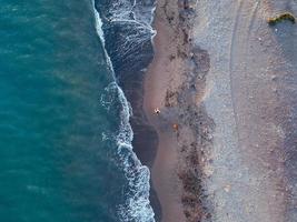 vistas aéreas de uma menina com seu cachorro em uma praia virgem, no parque natural punta entinas, almeria, espanha foto