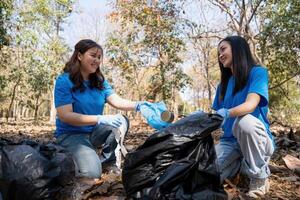 voluntário colecionar plástico Lixo dentro a floresta. a conceito do de Meio Ambiente conservação. global de Meio Ambiente poluição. limpeza a floresta foto