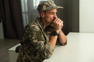 depressivo exército homem dentro uniforme sentado dentro a esvaziar sala. Lugar, colocar para seu poster em a parede foto