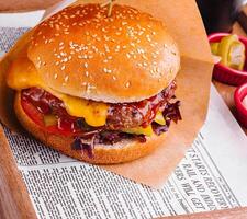 saboroso hamburguer com francês fritas em de madeira mesa foto