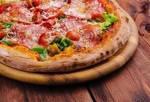 pizza com prosciutto carne, cereja tomates, Rúcula e parmesão queijo foto