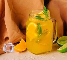 limonada com Lima, laranja e hortelã dentro uma vidro jarra foto