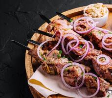 kebabs a partir de carne de porco em espetos em de madeira borda foto