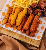 frito pepitas e picante frango pernas, asas e francês fritas batatas foto