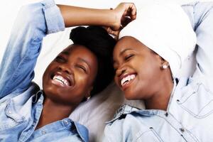 dois africano americano mulheres rindo retratos reclinável foto