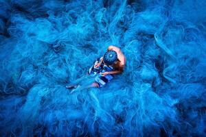 velho pescador mãos de costura azul pescaria redes sentado em a terra e cercado grande internet foto