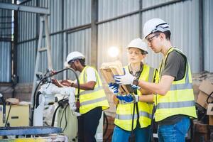 mecânico de equipe de engenheiros usando braço robótico de controlador de computador para soldar aço na oficina de fábrica de aço. software de programação de robôs da indústria para tecnologia de fabricação automatizada foto