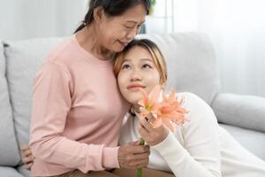 mãe dia, fofa ásia adolescente menina abraçando maduro meio era mãe. amor, beijo, Cuidado, feliz sorrir apreciar família tempo. comemoro especial ocasião, feliz aniversário, alegre Natal. especial dia foto