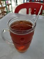caloroso chá dentro uma ampla vidro copo foto