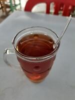 caloroso chá dentro uma ampla vidro copo foto