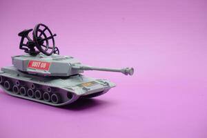cinzento brinquedo tanque isolado em roxa fundo. imitação do uma tanque comumente usava de a armado forças. foto