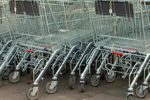 linha do compras carrinhos estão forrado acima em a terra foto