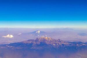 vôo avião sobre México nuvens céu vulcões montanhas cidade deserto. foto