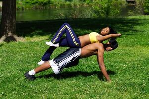 africano americano homem fazendo flexão com mulher em dele costas foto