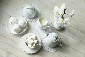 Primavera café da manhã com marshmallow, café e leite. flatlay com Comida e flor dentro branco cor foto