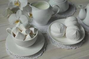 Primavera café da manhã com marshmallow, café e leite. flatlay com Comida e flor dentro branco cor foto