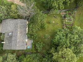 aéreo Visão do uma residencial casa e uma verde quintal com jardim dentro verão cenário foto
