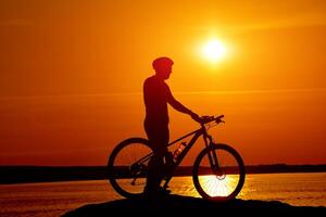 silhueta do raça ciclista. sombra atrás a Sol do ciclismo cara. foto