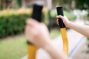 fechar acima do desportista mãos enquanto trabalhando Fora exercício equipamento ao ar livre dentro público parque. saudável estilo de vida conceito foto