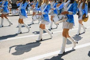 majorettes com branco e azul uniformes executar dentro a ruas do a cidade. fotográfico Series foto