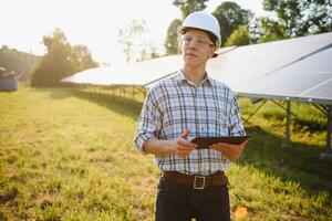 Planta de energia solar. homem de pé perto de painéis solares. energia renovável. foto