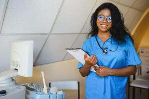 bonita fêmea africano médico enfermeira segurando prancheta foto