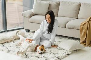 jovem mulher com dela fofa cachorro às lar. adorável animal. foto