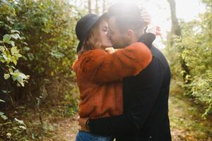 se beijando jovem casal dentro amor dentro a outono parque. foto