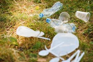 uma pilha do plástico em verde grama, uma problema dentro a natural ambiente, poluição do natureza é não decomposição plástico. proteção do natureza. foto