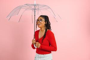 jovem africano americano mulher com afro cabelo debaixo guarda-chuva foto
