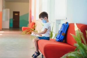 retrato do uma estudante em pé com uma mochila em a esvaziar escola corredor. costas para escola. foto