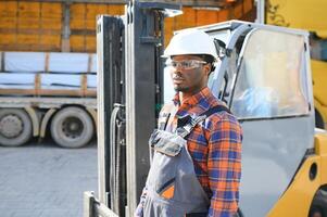 africano americano homem às trabalhar. profissional Operação Engenharia. jovem trabalhador empilhadeira motorista foto